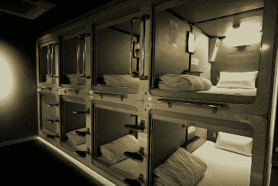 Two rows of 4 fullsize bed pods. One stacked on the other. Image stylized in sepia.